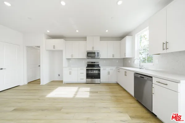 a kitchen with granite countertop a stove top oven sink and cabinets