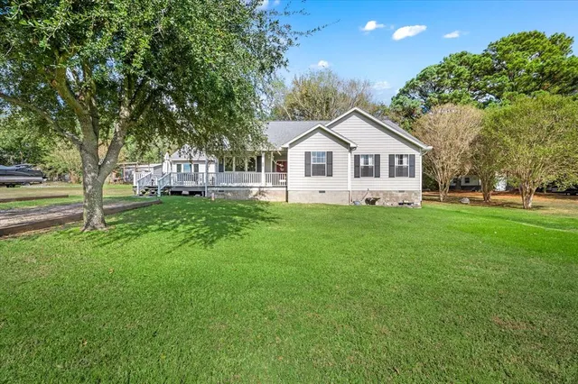 a front view of a house with a yard and trees