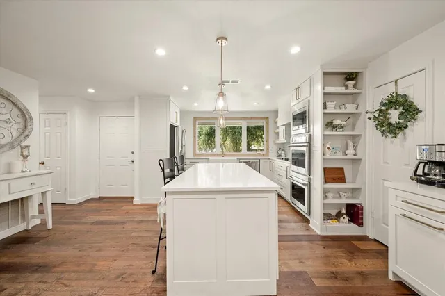 a kitchen with stainless steel appliances granite countertop a refrigerator a stove and a refrigerator