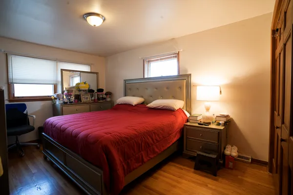a bedroom with a bed and wooden floor