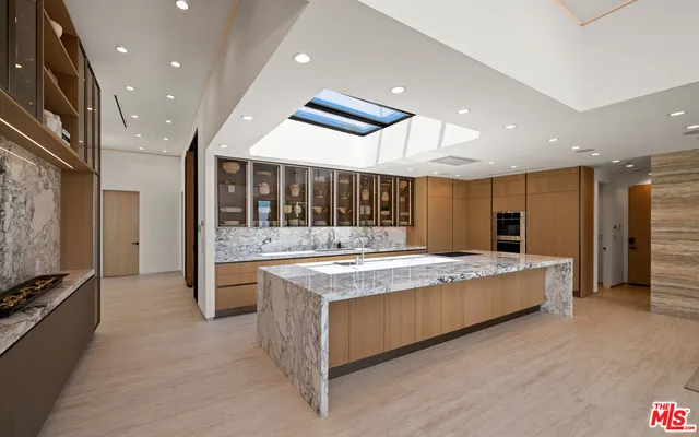 a large kitchen with lots of counter space a sink appliances and dining table