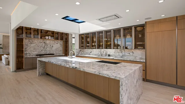 a large living room with stainless steel appliances granite countertop a couch and a large window