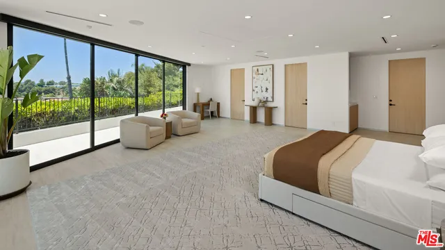 a bedroom with furniture and large windows