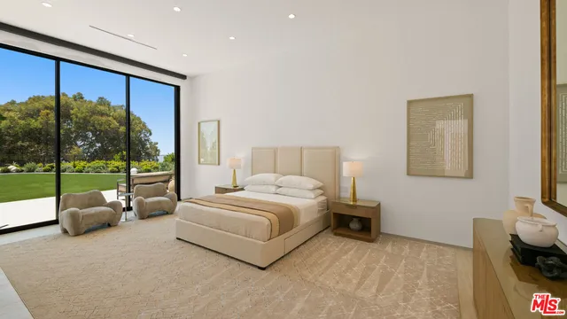 a spacious bedroom with a large bed and a large window