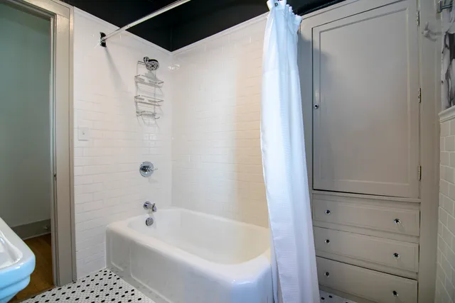 a bathroom with a bathtub a toilet and a shower