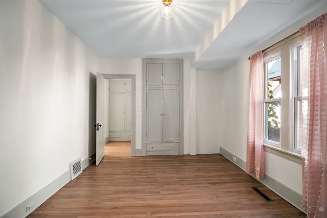 a view of hallway with wooden floor and chandelier