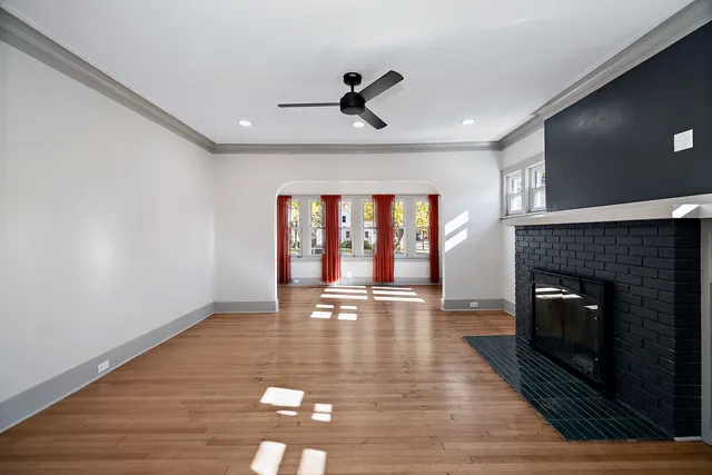 a view of empty room with wooden floor and fireplace