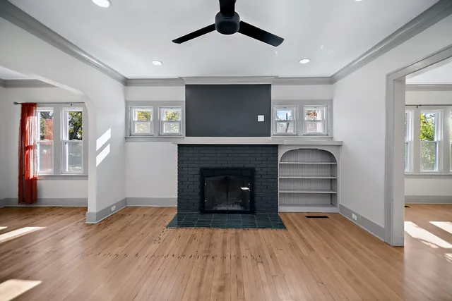 a living room with wooden floors and a fireplace