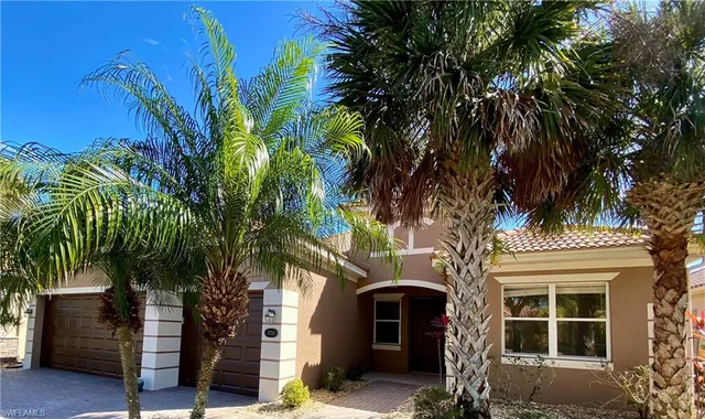 a front view of a house with a tree