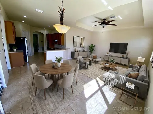 a living room with furniture a flat screen tv and kitchen view