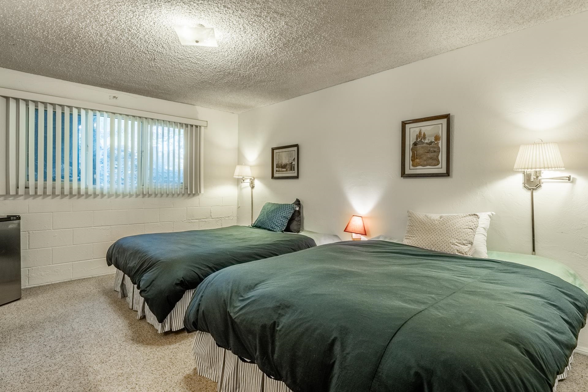 50 Hidden Valley Road, Unit 17 Mammoth Lakes, CA 93546 - Photo 26 of 40 Carpeted room featuring a window with horizontal blinds, painted block walls, and a textured ceiling