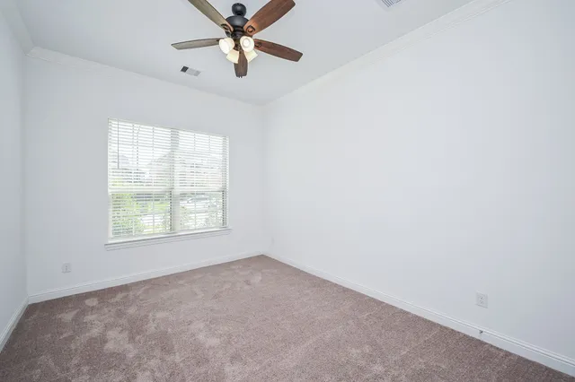 an empty room with a window and a fan