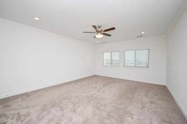an empty room with a window and a ceiling fan