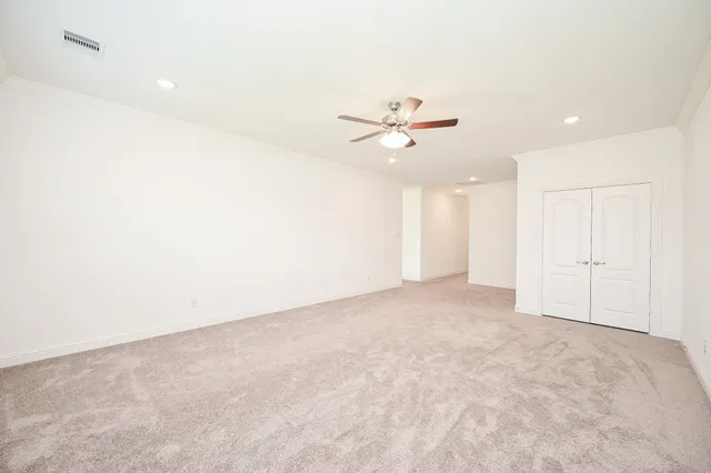 an empty room with a ceiling fan and a window