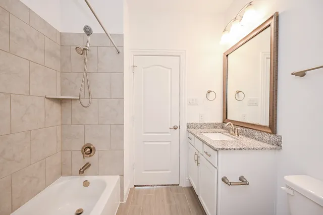 a bathroom with a granite countertop tub sink and mirror