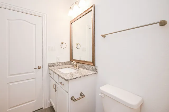 a bathroom with a granite countertop sink and a mirror