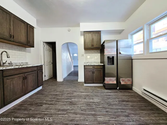 a kitchen with stainless steel appliances granite countertop a refrigerator a stove and a sink