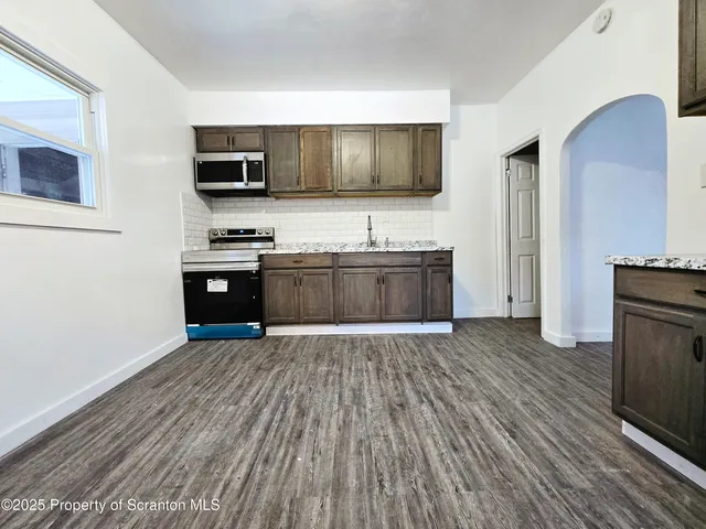 a kitchen with stainless steel appliances a stove top oven a sink and a refrigerator