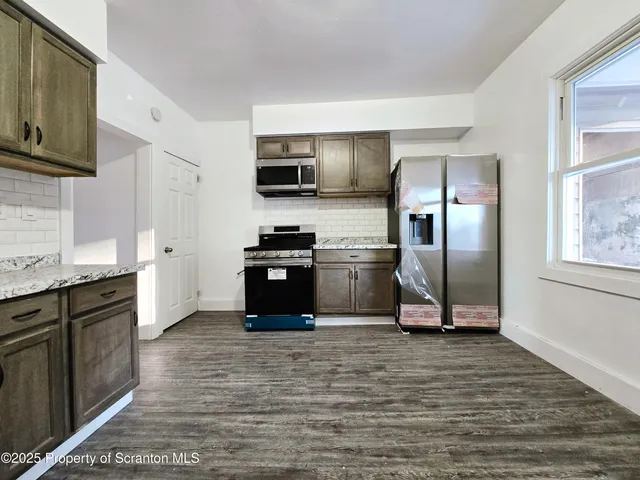 a kitchen with granite countertop a refrigerator and a sink