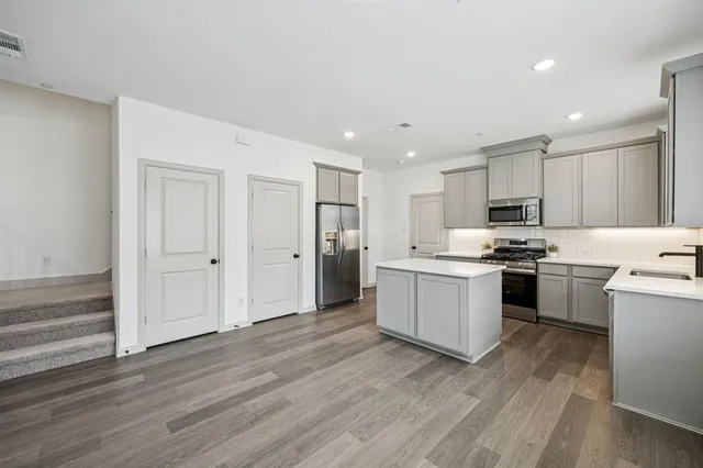 a kitchen with a refrigerator and a stove top oven