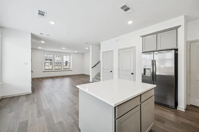 a kitchen with a refrigerator a sink and a stove top oven