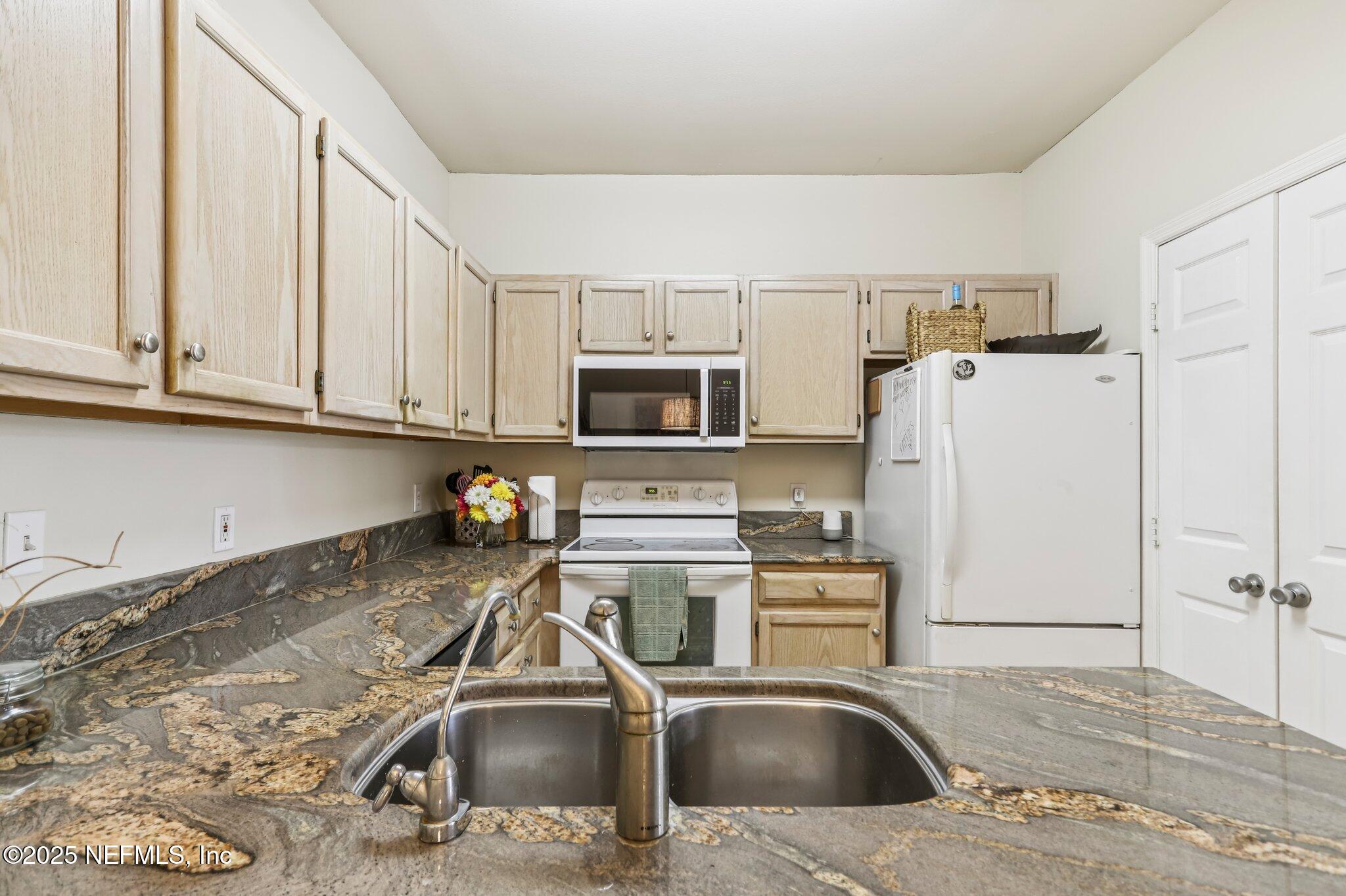 201 Colima Court, Unit 1221 Ponte Vedra Beach, FL 32082 - Photo 17 of 50 a kitchen with stainless steel appliances granite countertop a sink a stove and refrigerator