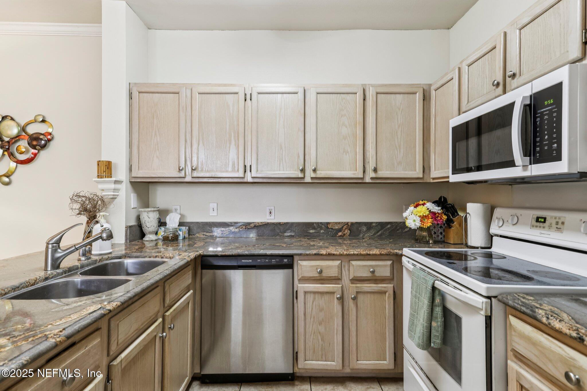 201 Colima Court, Unit 1221 Ponte Vedra Beach, FL 32082 - Photo 19 of 50 a kitchen with stainless steel appliances granite countertop white cabinets a sink and dishwasher