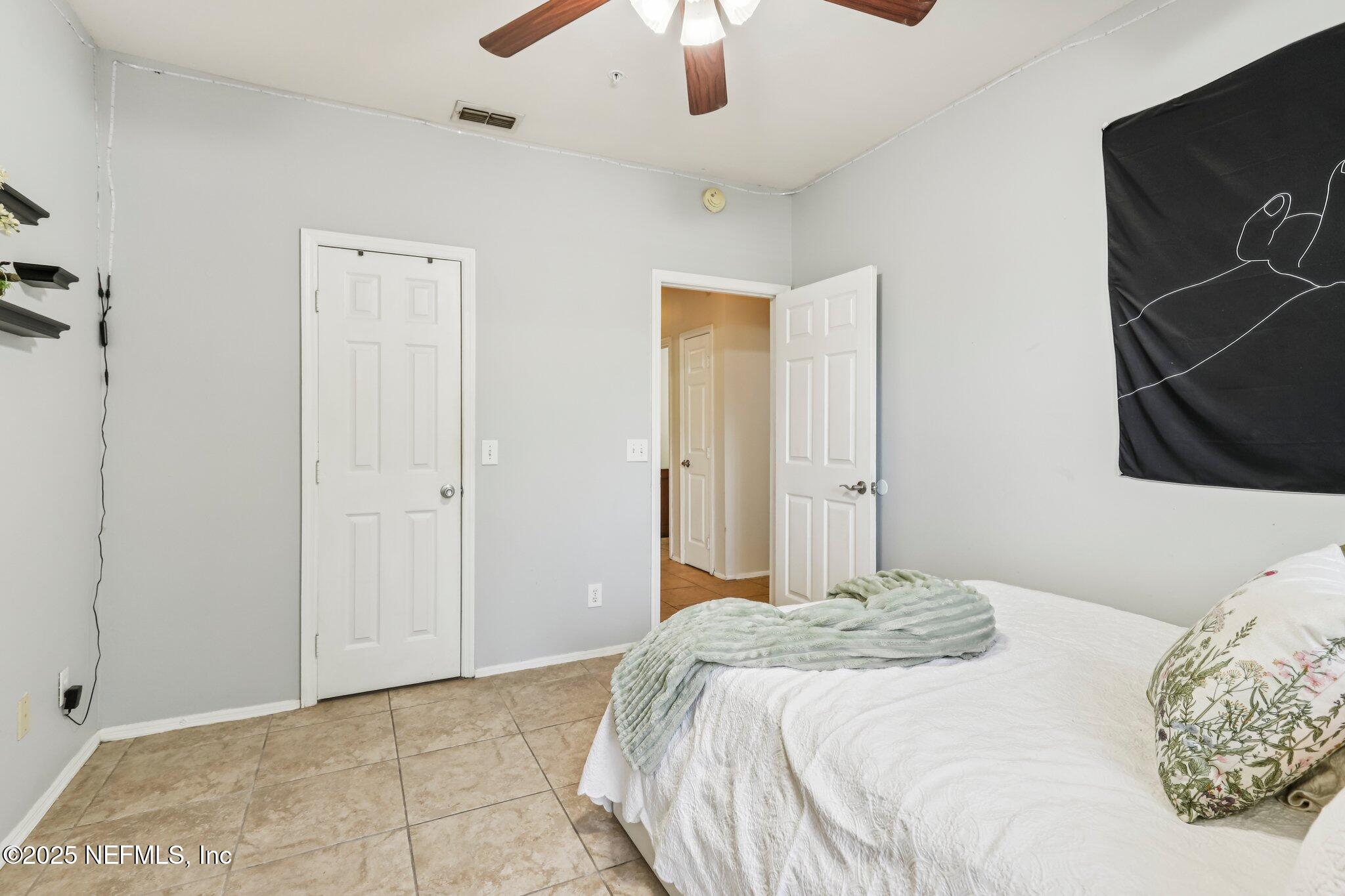 201 Colima Court, Unit 1221 Ponte Vedra Beach, FL 32082 - Photo 27 of 50 a bedroom with a bed and a chandelier fan