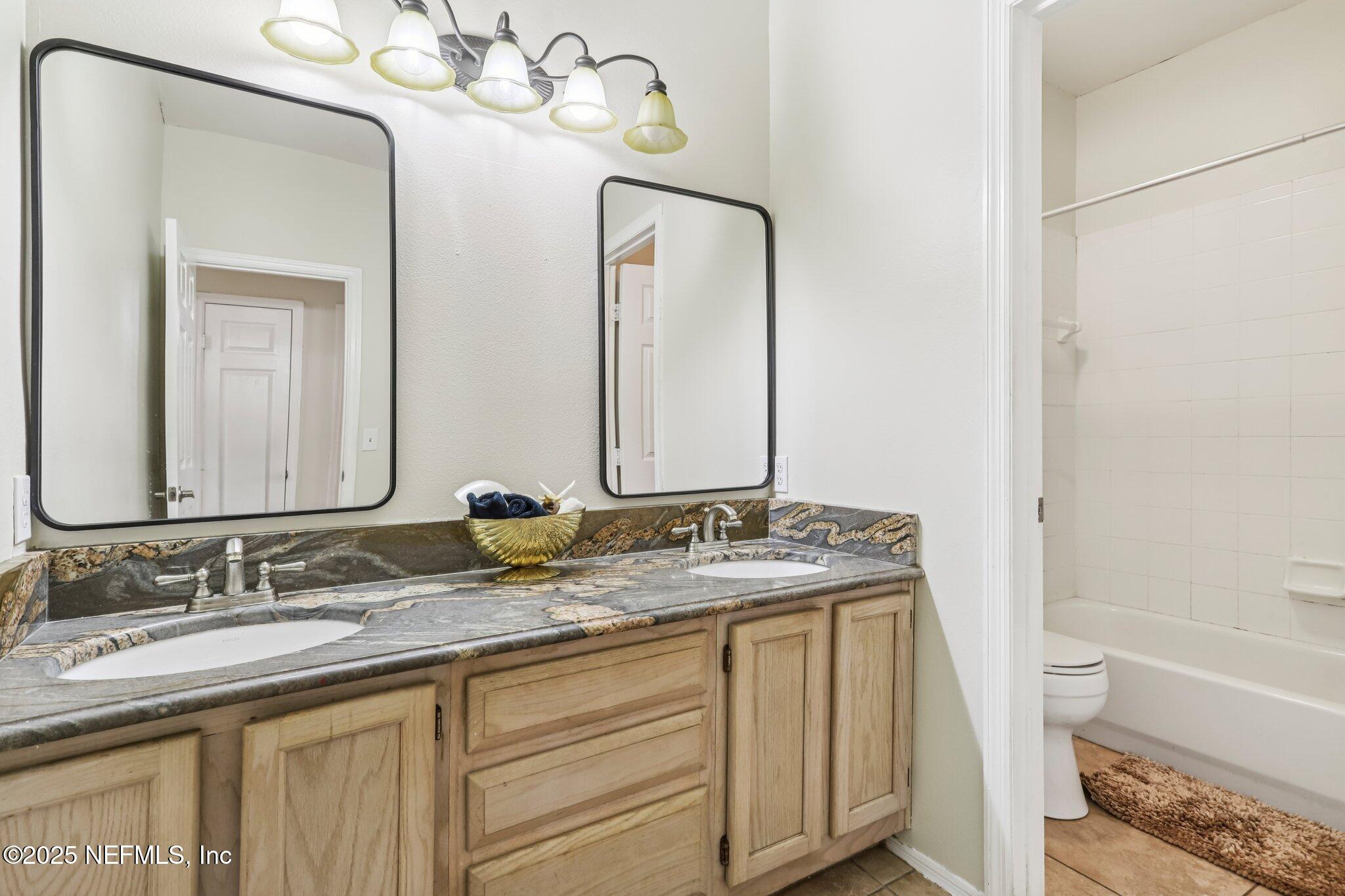 201 Colima Court, Unit 1221 Ponte Vedra Beach, FL 32082 - Photo 29 of 50 a bathroom with a granite countertop sink and a mirror