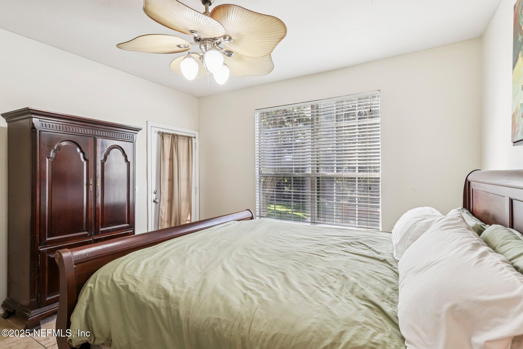 201 Colima Court, Unit 1221 Ponte Vedra Beach, FL 32082 - Photo 31 of 50 a bedroom with a large bed and a chandelier