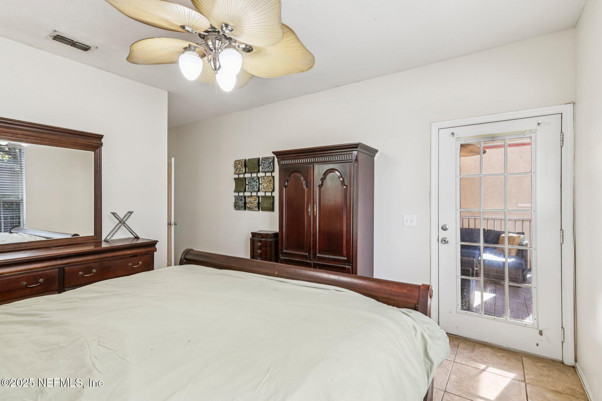 201 Colima Court, Unit 1221 Ponte Vedra Beach, FL 32082 - Photo 33 of 50 a bedroom with a bed and a chandelier