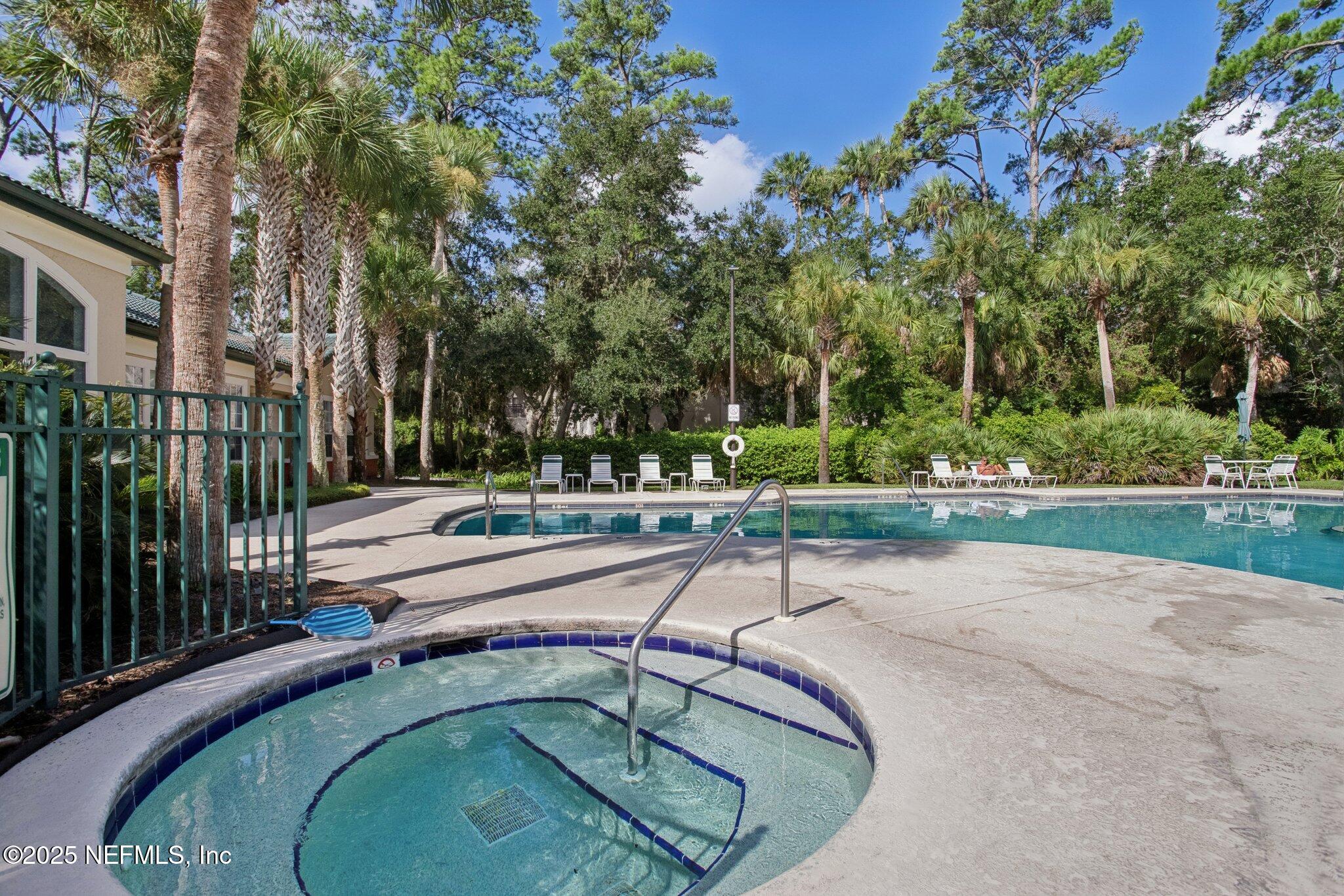 201 Colima Court, Unit 1221 Ponte Vedra Beach, FL 32082 - Photo 45 of 50 a swimming pool with outdoor seating and garden