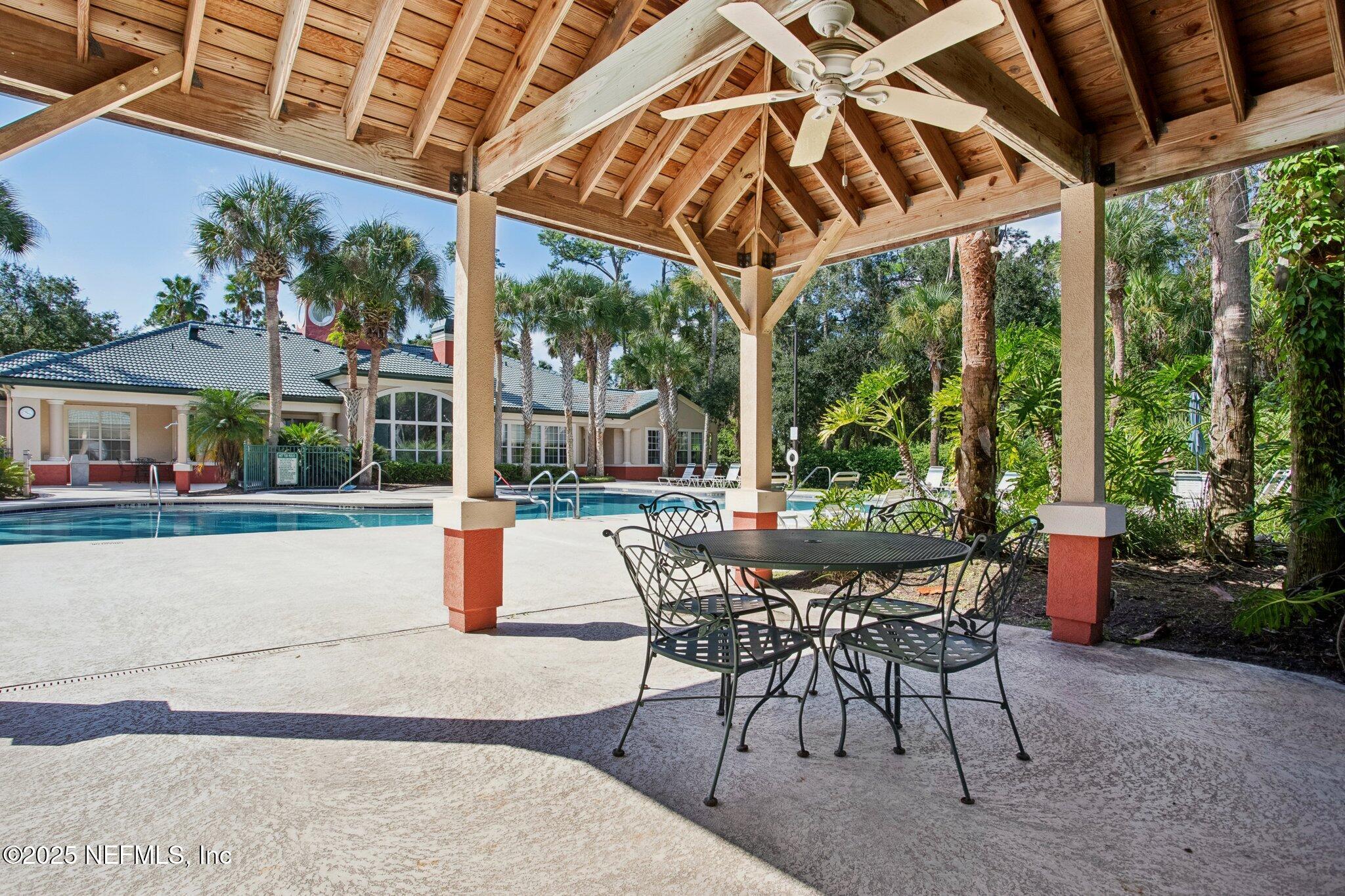 201 Colima Court, Unit 1221 Ponte Vedra Beach, FL 32082 - Photo 49 of 50 a patio with yard glass top table and chairs