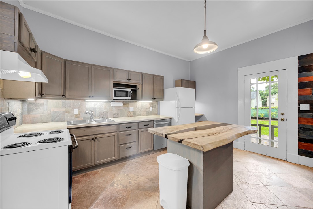 308 Verner Street Walhalla, SC 29691 - Photo 12 of 49 Natural stone tile floors and a rustic live-edge island anchor this well-appointed kitchen space.