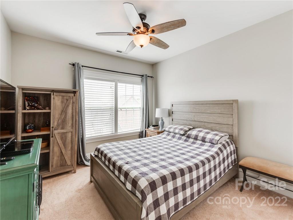 326 Mariemont Way Rock Hill, SC 29730 - Photo 25 of 36 a bedroom with a bed a window and a chandelier