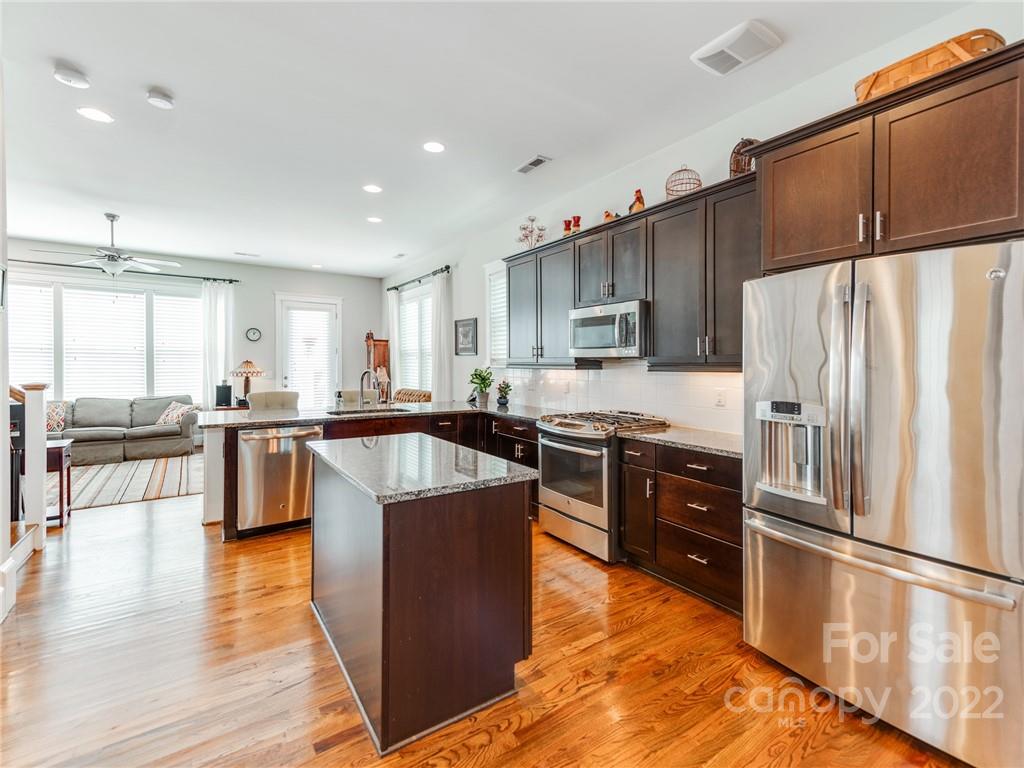 326 Mariemont Way Rock Hill, SC 29730 - Photo 9 of 36 a kitchen with stainless steel appliances wooden cabinets a refrigerator a stove a sink dishwasher a oven and a refrigerator with wooden floor
