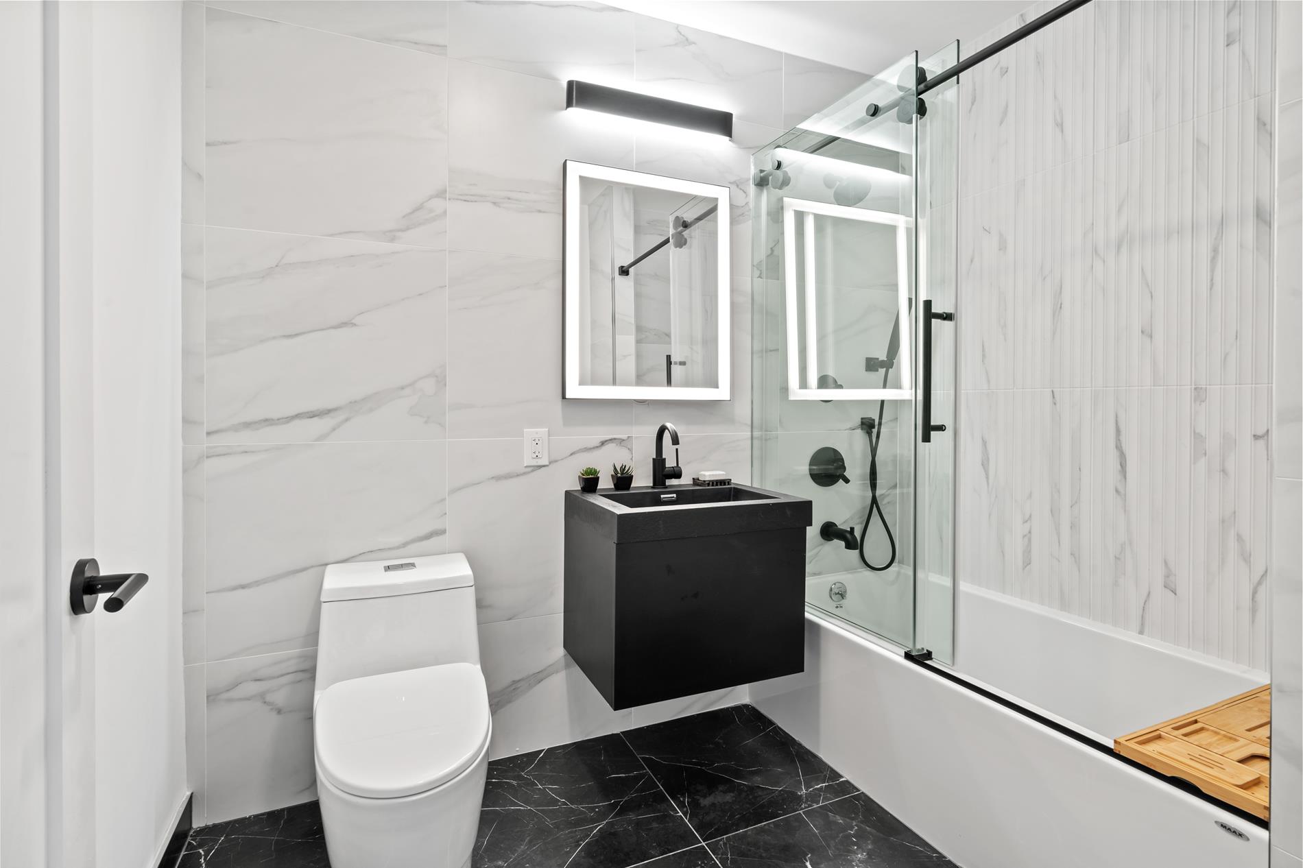 322 Lincoln Road, Unit 4A Brooklyn, NY 11225 - Photo 6 of 8 a bathroom with a granite countertop toilet sink and mirror