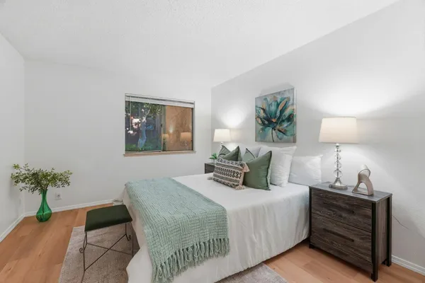 a bedroom with a bed lamp and a potted plant