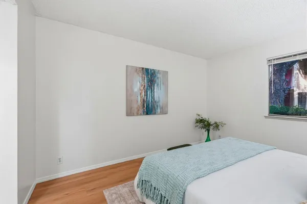 a bedroom with a bed and a painting on the wall
