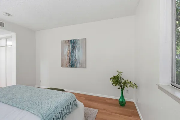 a bedroom with a bed and a potted plant