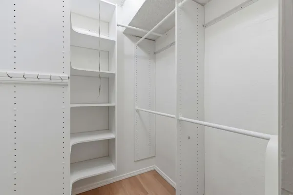 a view of walk in closet with empty racks