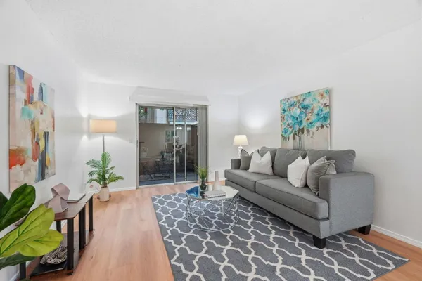 a living room with furniture a lamp and a potted plant