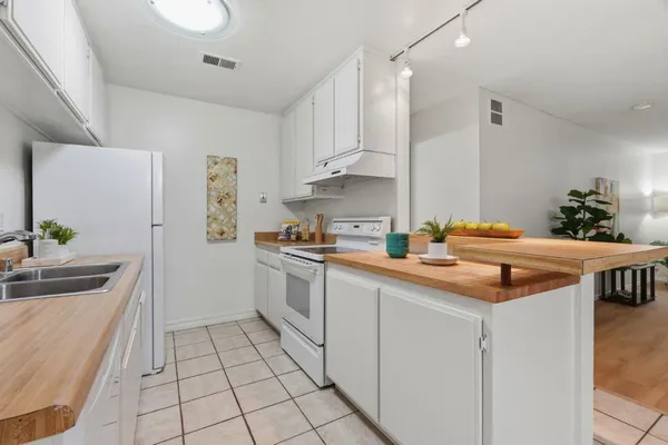 a kitchen with stainless steel appliances kitchen island granite countertop a sink and a cabinets