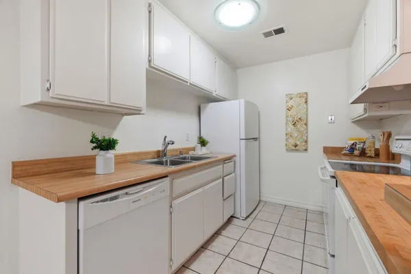 a kitchen with stainless steel appliances granite countertop a sink and a refrigerator