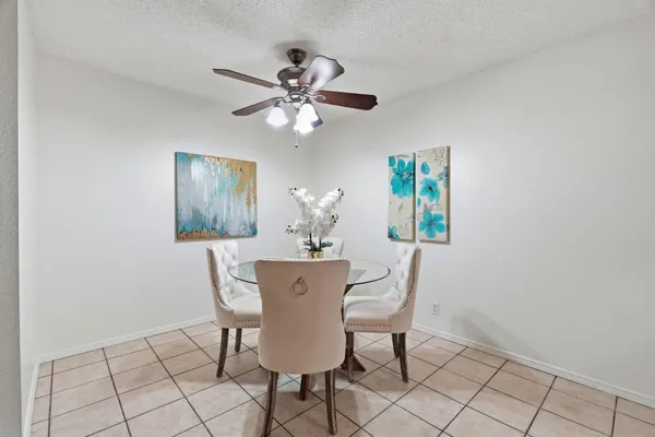 a view of a dining room with furniture and a chandelier fan