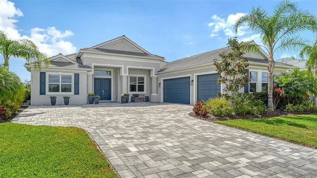 a front view of a house with a yard and potted plants