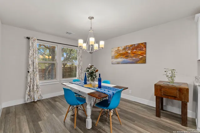 a view of a dining room with furniture wooden floor and a chandelier