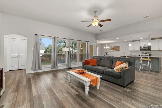 a living room with furniture and a wooden floor