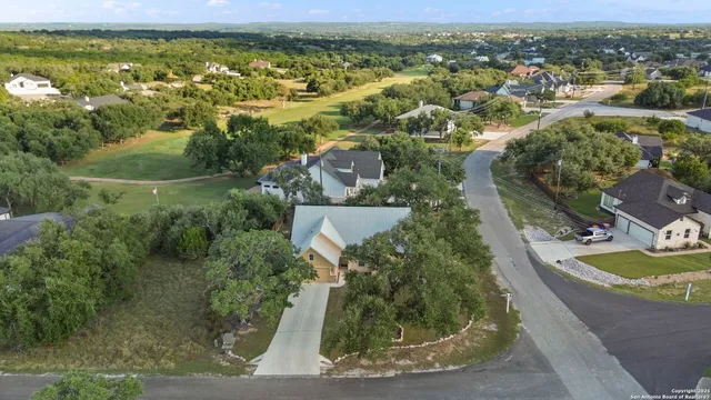 an aerial view of residential houses with outdoor space and trees