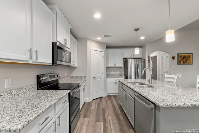 a kitchen with stainless steel appliances granite countertop a sink stove and refrigerator